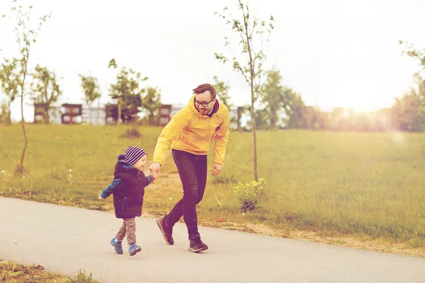 Счастливый отец и маленький сын гуляет на улице — стоковое фото