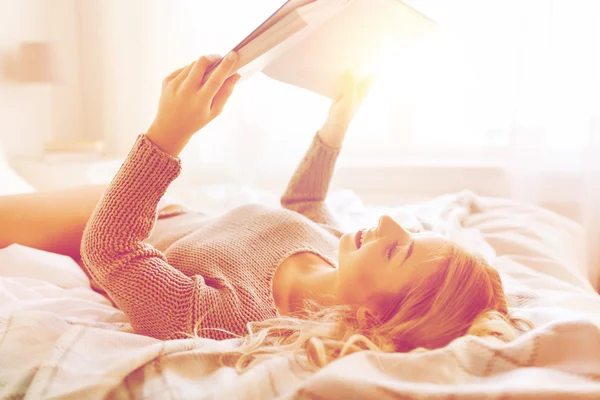 Jovem mulher ler livro na cama em casa — Fotografia de Stock