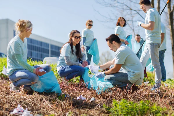 Voluntários com sacos de lixo área do parque de limpeza — Fotografia de Stock