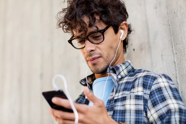Чоловік з навушниками та смартфоном слухає музику — стокове фото