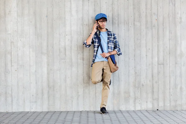 Homem com saco chamando no smartphone na parede de rua — Fotografia de Stock