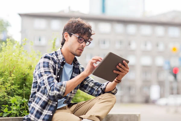 Man with tablet pc sitting on city street bench — Stock Photo, Image