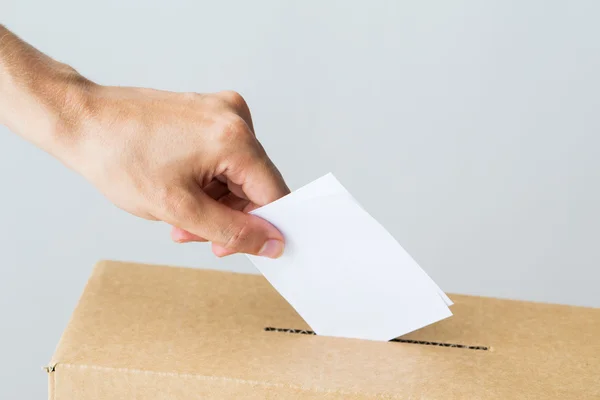Man putting his vote into ballot box on election — Stock Photo, Image