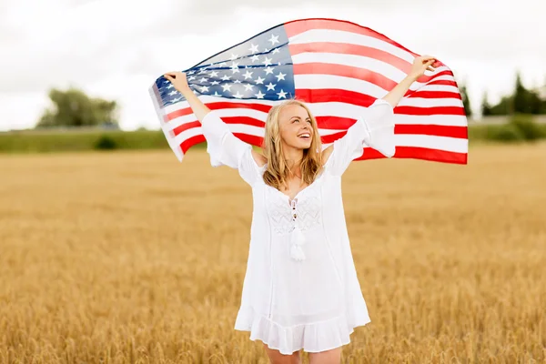 Щаслива жінка з американським прапором на зерновому полі — стокове фото