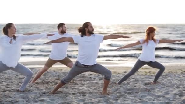 Grupp av människor att göra yogaövningar på stranden — Stockvideo