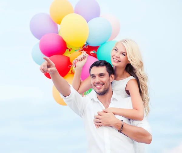 Coppia con palloncini colorati lato mare — Foto Stock