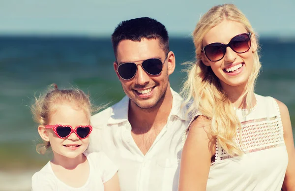 Yaz plajında güneş gözlüklü mutlu bir aile. — Stok fotoğraf