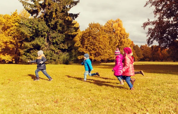 Grupo de niños pequeños y felices corriendo al aire libre —  Fotos de Stock