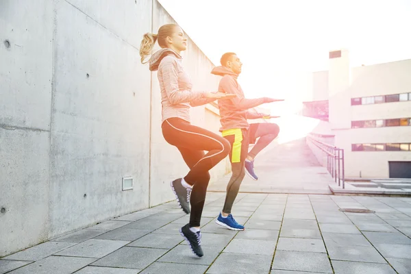 Happy man and woman jumping outdoors — Stock Photo, Image