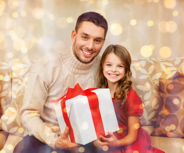 Smiling father and daughter holding gift box — Stock Photo, Image