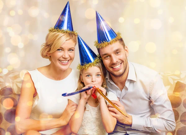 파란색 모자 호의 뿔을 불고 웃는 가족 — 스톡 사진