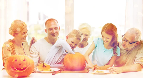 Happy family sitting with pumpkins at home — Stock Photo, Image