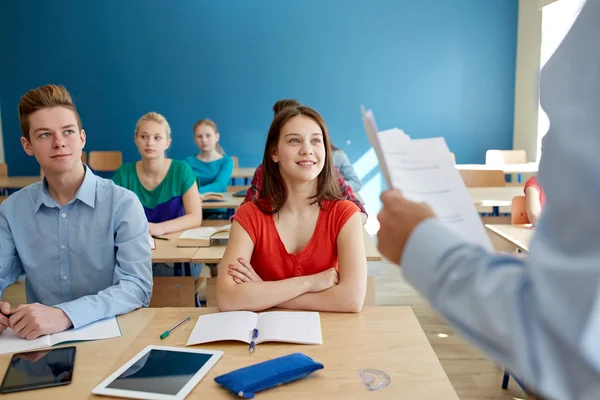 Group of students and teacher with papers or tests — Stock Photo, Image