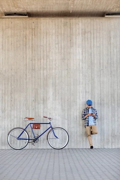 Hombre con smartphone, auriculares y bicicleta —  Fotos de Stock