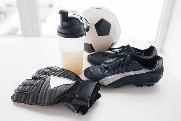 Närbild av fotboll, stövlar, handskar och flaska — Stockfoto