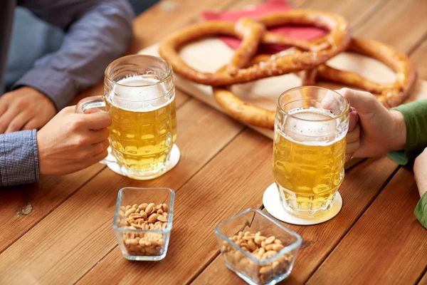 Close up of hands with beer mugs at bar or pub — Stock Photo, Image