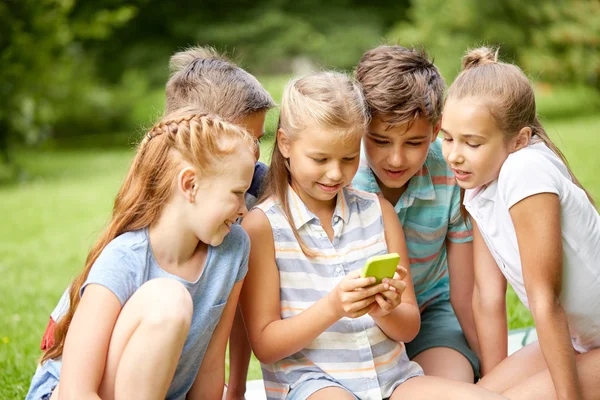 Barn eller vänner med smartphone i sommaren park — Stockfoto