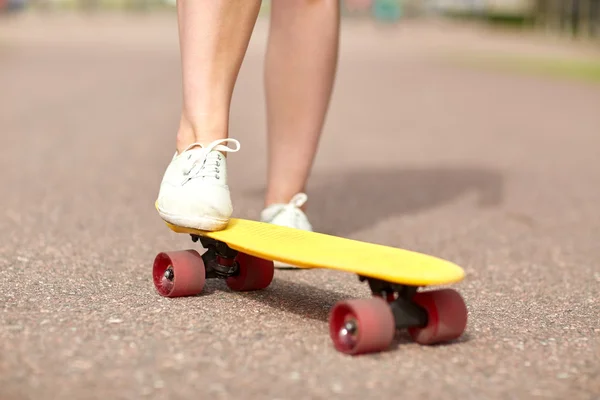 Gros plan de pieds féminins chevauchant skateboard court — Photo