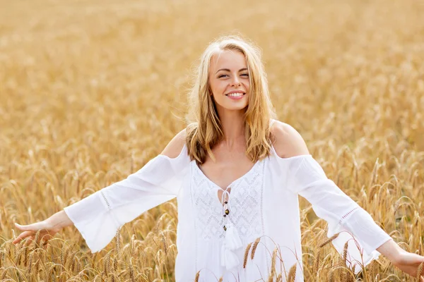 Mosolygós fiatal nő fehér ruhában a gabona mező — Stock Fotó
