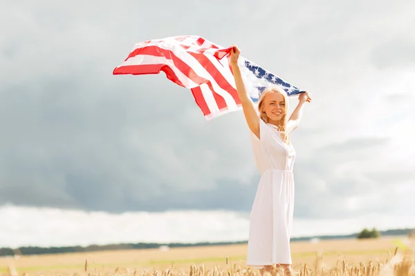 Mujer feliz con bandera americana en el campo de cereales —  Fotos de Stock