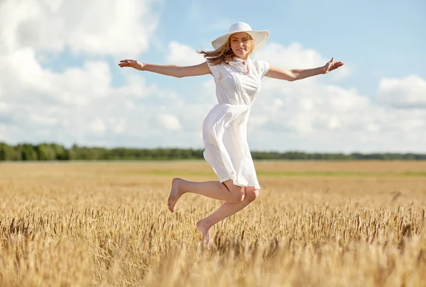 Glückliche junge Frau springt auf Getreidefeld — Stockfoto
