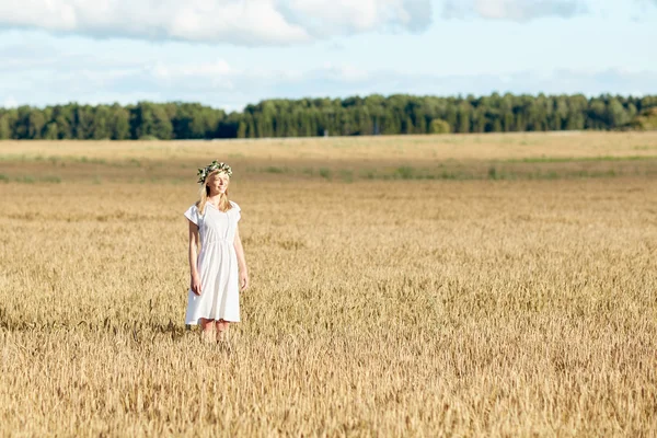 Gelukkig jong vrouw in bloem krans op graan veld — Stockfoto