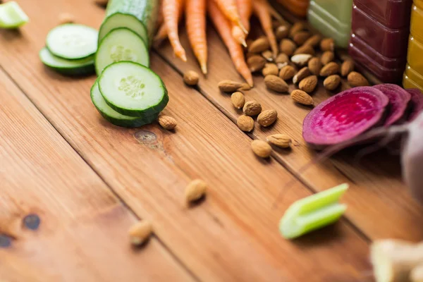 Different vegetables and almond nuts on wood — Stock Photo, Image