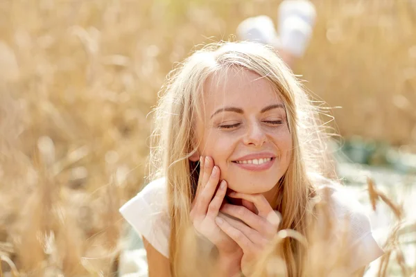 Mujer feliz o chica adolescente acostada en el campo de cereales —  Fotos de Stock