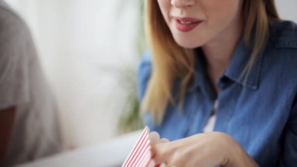 Lycklig kvinna äta popcorn och titta på tv hemma — Stockvideo