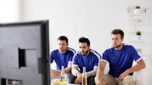Друзі або шанувальники футболу дивляться футбол вдома — стокове відео