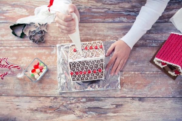 Close up of woman making gingerbread houses — Stock Photo, Image