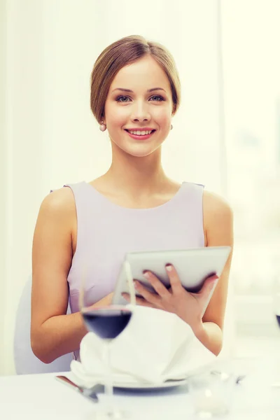 Mujer sonriente con tableta PC en el restaurante — Foto de Stock