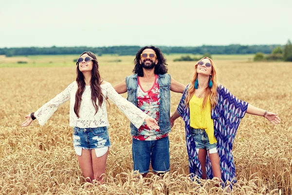 Sonriendo jóvenes amigos hippies en el campo de cereales —  Fotos de Stock