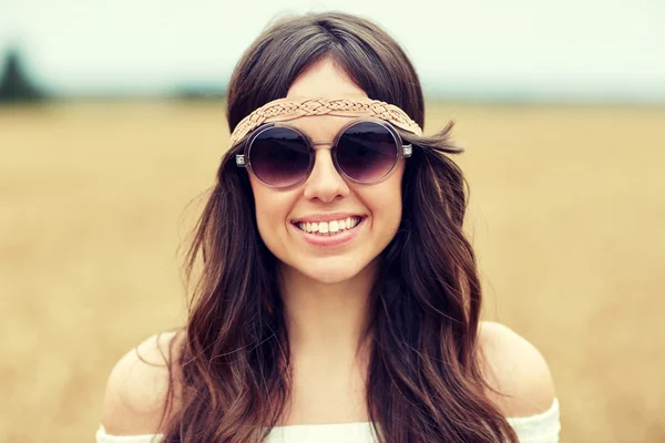 Glimlachend jonge hippie vrouw in zonnebril buitenshuis — Stockfoto