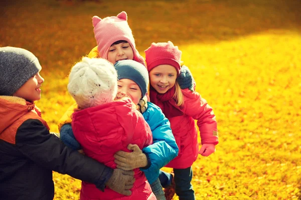 Grupa dzieci szczęśliwy tulenie w parku jesień — Zdjęcie stockowe
