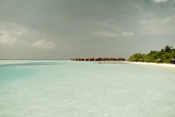 Καλύβες μπανγκαλόου στο νερό της θάλασσας στην παραλία εξωτικό θέρετρο — Φωτογραφία Αρχείου