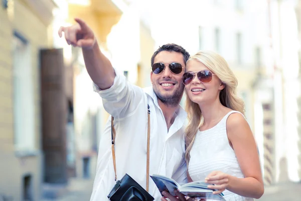 Couple with map, camera and travellers guide Royalty Free Stock Photos