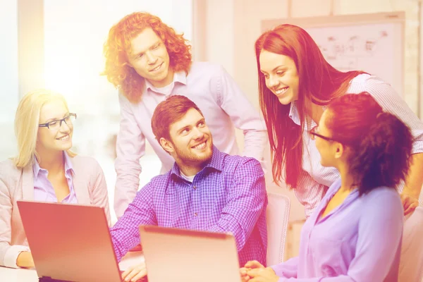 Lächelndes Team mit Laptop im Büro — Stockfoto