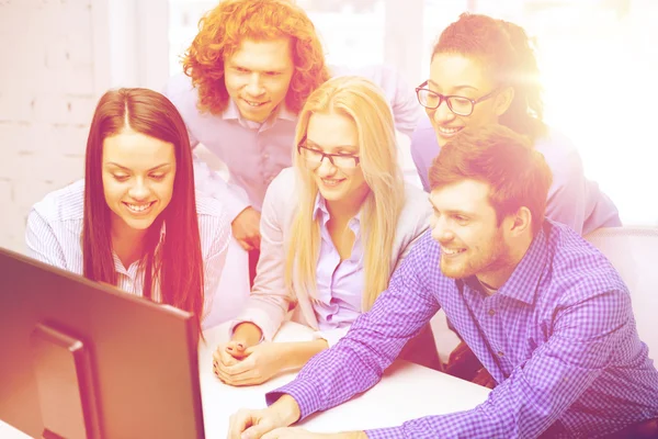 Smiling business team looking at computer monitor — Stock Photo, Image