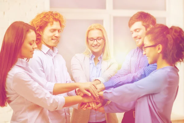 Equipe com as mãos em cima umas das outras no escritório — Fotografia de Stock