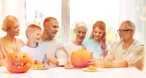 Happy family sitting with pumpkins at home — Stock Photo, Image