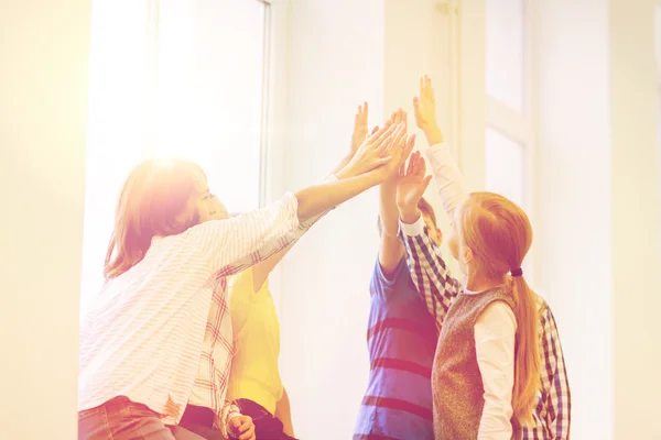 Group of school kids making high five gesture — Stockfoto