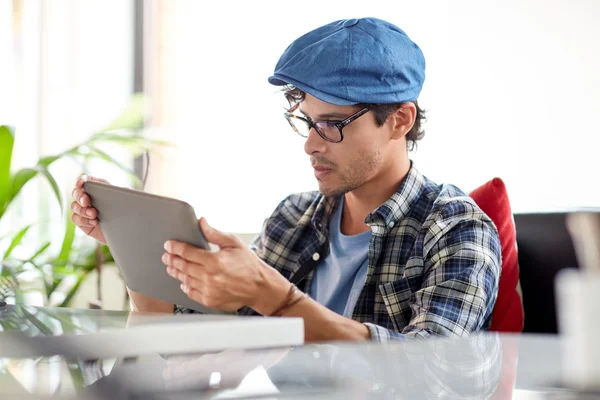 Человек с планшетным компьютером, сидящий за столиком кафе — стоковое фото