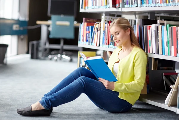 Estudiante de secundaria chica leyendo libro en la biblioteca —  Fotos de Stock