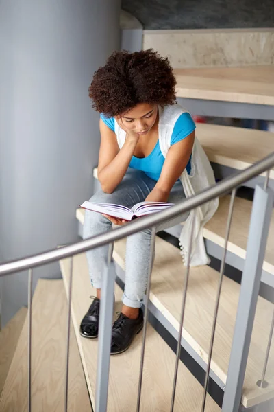 Afrikalı öğrenci kız merdivenlerde kitap okuma — Stok fotoğraf