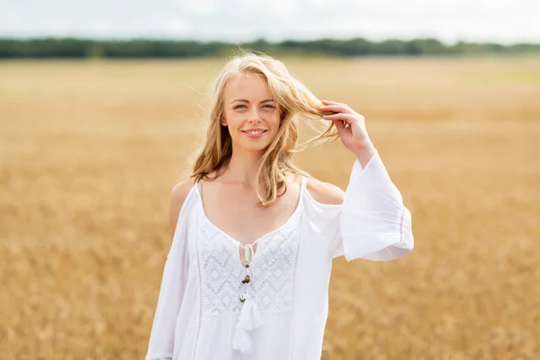 Giovane donna sorridente in abito bianco sul campo di cereali — Foto Stock