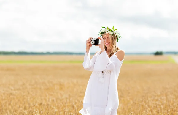 Femme heureuse avec caméra de film en couronne de fleurs — Photo