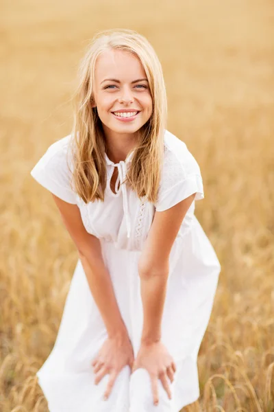 Jeune femme souriante en robe blanche sur le champ de céréales — Photo