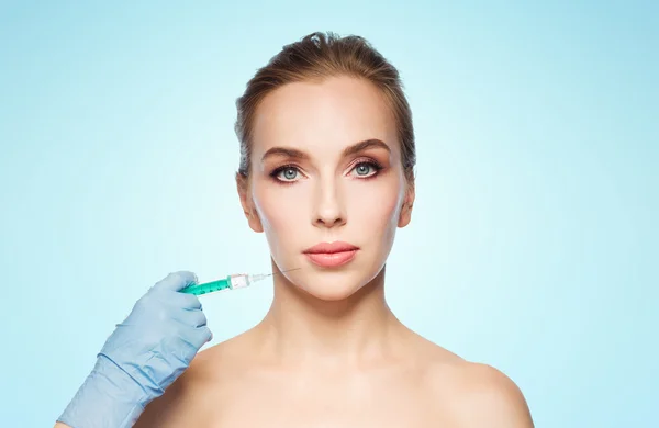 Vrouw gezicht en hand met maken van injectie spuit — Stockfoto