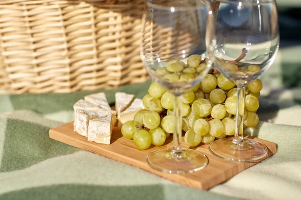 Picnic basket with wine glasses, grapes and cheese — Stock Photo, Image